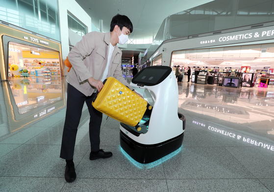 A man uses an autonomous cart at the departure gate of Incheon International Airport's Terminal 2 on Wednesday. Incheon International Airport said it is operating a trial run for the indoor autonomous vehicles, the first airport in the world to do so. [YONHAP] 