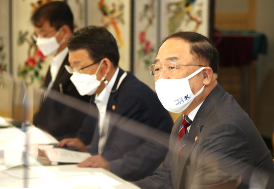 Finance Minister Hong Nam-ki, right, speeaks during the government's meeting on real estate market held at the government complex in Seoul on Wednesday. [YONHAP]