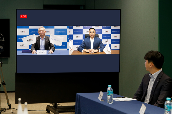 Amorepacific Group President Ahn Se-hong, left, and China Duty Free Group CEO Charles Chen attend a signing ceremony on Tuesday. [AMORE PACIFIC]