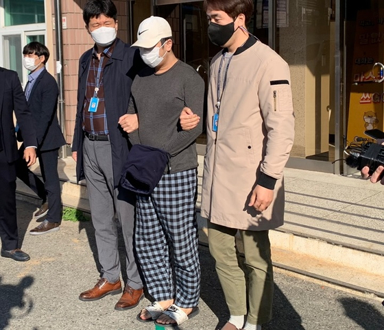 The operator of a now-defunct website that disclosed the identities and personal information of sex offenders and suspects, center, leaves the Daegu Metropolitan Police Agency Thursday morning to be referred to prosecutors. [KIM JUNG-SEOK] 