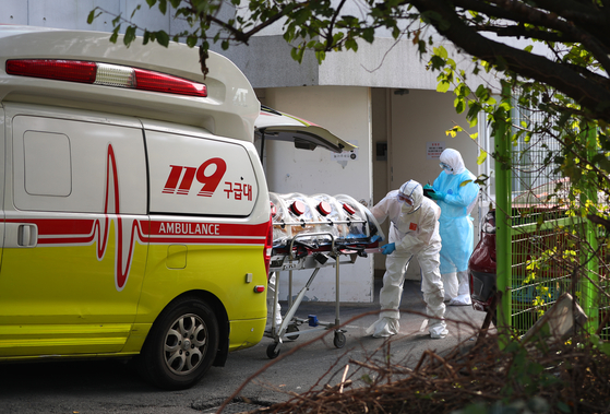 A coronavirus patient at a hospital for senior citizens in Busan gets transferred to a different hospital Wednesday after developing severe symptoms. At least 53 Covid-19 cases have been traced to the Busan hospital, making it the largest cluster the city has seen. [YONHAP] 