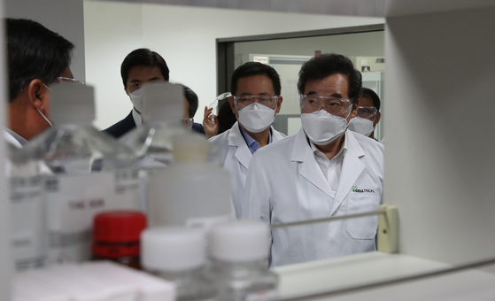 Ruling Democratic Party (DP) Chairman Lee Nak-yon, right, visits a Celltrion factory in Yeonsu District in Incheon Sunday and is briefed on Covid-19 treatment development. Later in the day Lee met with Takeo Kawamura, former Japanese chief cabinet secretary and current head of the Japan-Korea parliamentary group, to discuss bilateral issues. [NEWS1]