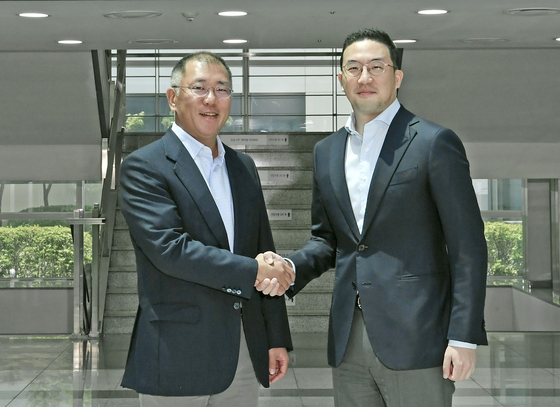 Hyundai Motor Group Chairman Euisun Chung, left, shakes hands with LG Group Chairman Koo Kwang-mo at LG Chem's battery factory in Ochang, North Chungcheong, in June. [HYUNDAI MOTOR GROUP]