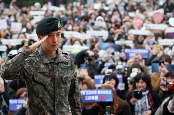 Singer Jung Yong-hwa salutes as fans await to welcome him back on Nov. 3, 2019, after he finished his two-year mandatory military service. [YONHAP]