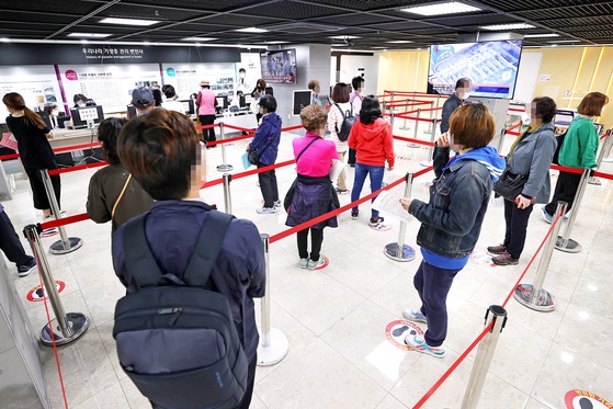 A day earlier on Tuesday, many people line up to get flu shots at the same health clinic. [YONHAP]