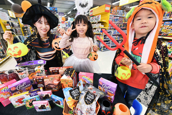 Models pose with Halloween-related merchandise at Homeplus’ Gangseo branch in western Seoul on Wednesday. The retailer said it is holding a special event celebrating the spooky celebration until the end of this month including selling 20,000 bottles of a limited Halloween edition of Seoul Milk’s ABC Juice. [HOMEPLUS]