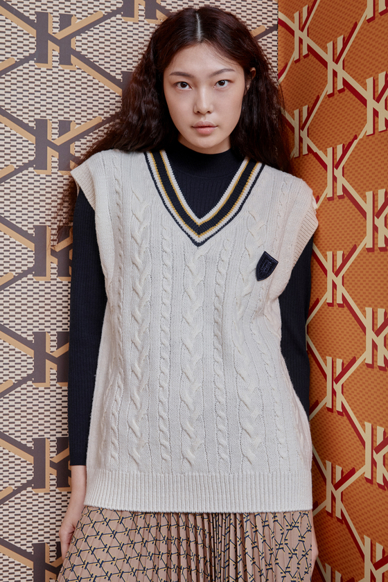 A model in a knitted vest presents a preppy look. [HAZZYS]