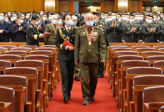 A Chinese People's Volunteers veteran enters the venue of the meeting marking the 70th anniversary of the CPV entering North Korea to participate in the Korean War at the Great Hall of the People in Beijing on Friday.  [XINHUA] 