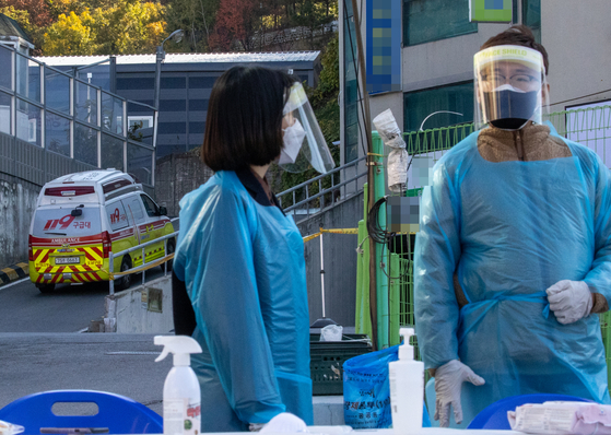 An ambulance enters a building linked to a Covid-19 outbreak in Namyangju, Gyeonggi, on Friday. [YONHAP]