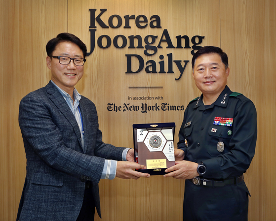 Lt. Gen. Chung Jin-kyung, right, superintendent of the Korea Military Academy, awards a plaque of appreciation to Ryu Kwon-ha, left, CEO of the Korea JoongAng Daily, to recognize his contribution to the education of cadets, at the paper's office in Sangam-dong, western Seoul, on Monday.  [PARK SANG-MOON]