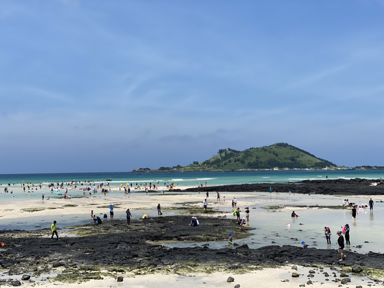 Jeju Island tourists spend time on the beach on Aug. 14. [CHOI CHOONG-IL] 
