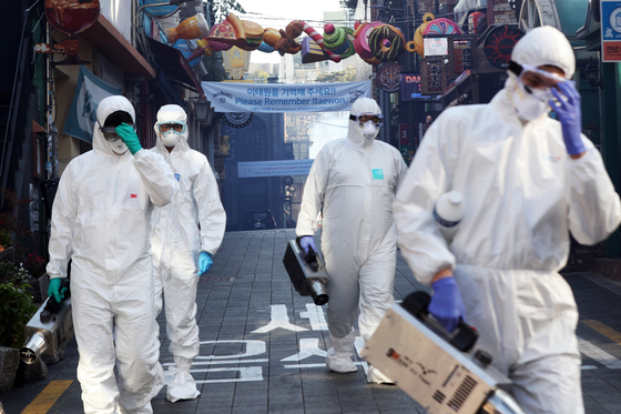 Officials from the Yongsan District Office disinfect streets in Itaewon, central Seoul, on Thursday ahead of Halloween in efforts to prevent new infections of Covid-19. [NEWS1]