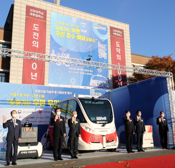 Participants in Korea Post's demonstration event on Wednesday are photographed at Korea University's Sejong Campus, where the event took place. The event showcased new high-tech postal service devices, such as an autonomous post office and an assistant delivery robot. [NEWS 1]