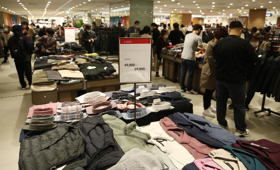 Shoppers browse discounted clothes at a department store in Seoul on Sunday as this year's Korea Sale Festa began. The nationwide shopping promotion that takes place at 1,633 department stores, supermarkets and convenience stores will run through Nov. 15 and offer a wide range of discounts. [YONHAP]