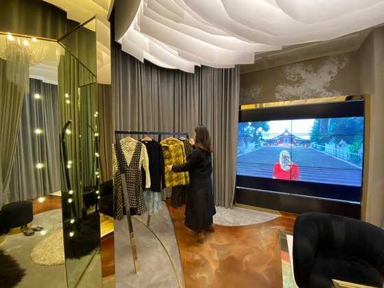 An employee organizes clothes hung on the rack at a personal shopping space for VIP customers, at Avenuel of Lotte Tower. [LOTTE DEPARTMENT STORE]