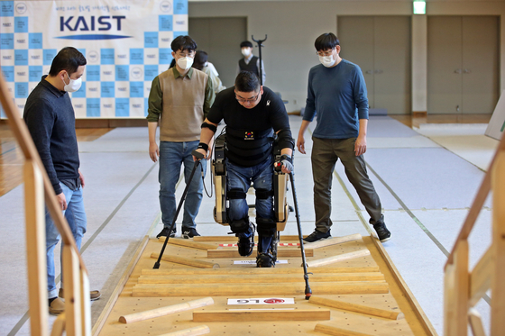 Kim Byeong-uk, who is paralyzed, walks over obstacles with an exoskeleton developed by a KAIST team and Yonsei University’s Severance Hospital during a Cybathlon competition held in Daejeon on Wednesday. The international competition was supposed to take place in May in Switzerland, but it was postponed due to the Covid-19 pandemic. [YONHAP]