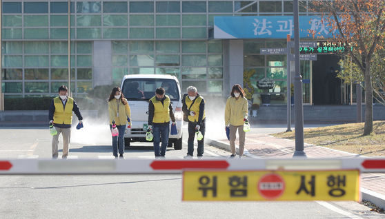 Health officials disinfect a prison in Gwangju on Monday after a worker tested positive that morning. [YONHAP]