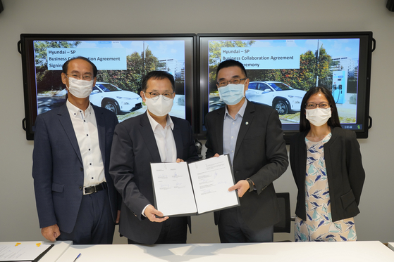 Hong Bum-jung, head of SF Innovation Center, second from left, and Chua Kee Heng, managing director of SP Group, pose for a photo after signing an agreement at SP Group headquarters in Singapore. [HYUNDAI MOTOR GROUP]