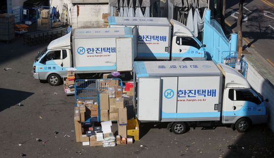 Parcel delivery workers load their trucks at a logistics center in Seoul on Nov.12. Working conditions of delivery workers have become a major social issue as the volume of parcels has increased thanks to the coronavirus outbreak. [YONHAP]