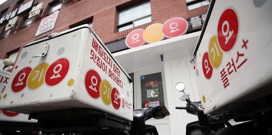 Motorcycles used to deliver food ordered on Yogiyo are parked in front of a restaurant in Seoul. [YONHAP]