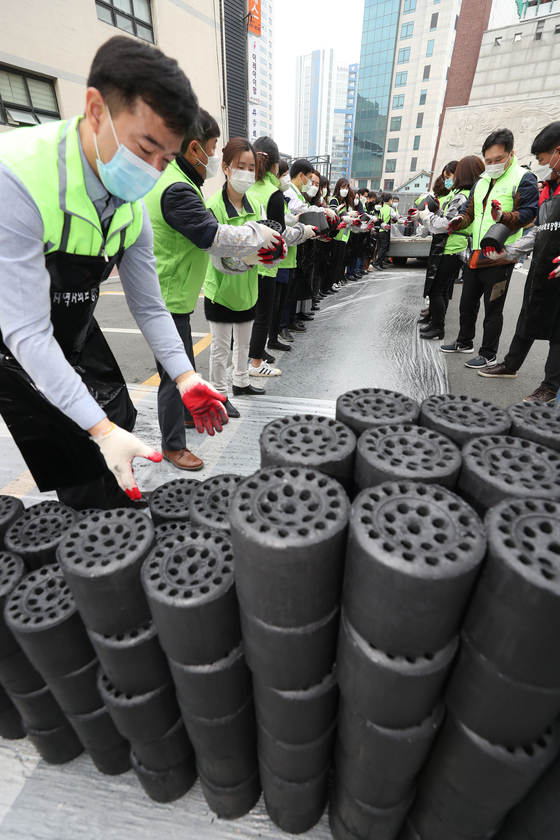 Welfare workers in Daegu on Tuesday deliver coal briquettes, a heating fuel for low-income households in a shanty town in the city.  [YONHAP]