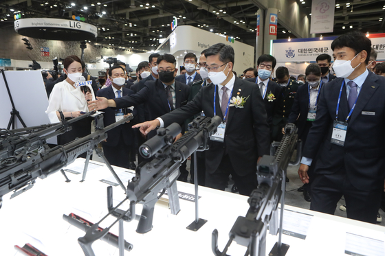 Defense Minister Suh Wook, center, looks at guns on display at the Defense & Security Expo Korea 2020, held at the Kintex Convention Center in Goyang, Gyeonggi, on Wednesday. [YONHAP]