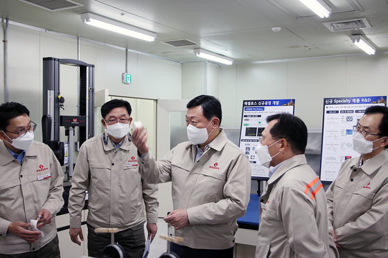 Lotte Chairman Shin Dong-bin, center, examines the production facilities at Lotte Fine Chemical’s plant in Ulsan. [LOTTE FINE CHEMICAL]