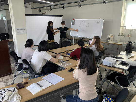 Young designers of Agoing, a fashion brand funded by the Seoul Metropolitan Government, gather at Maker Space in Yongsan District for a workshop. The area was also remodeled using city funds. [URBAN REGENERATION CENTER OF THE SEOUL METROPOLITAN GOVERNMENT]