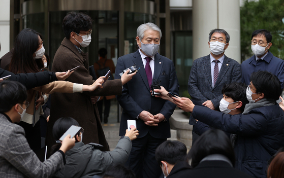 Kim Yong-ik, president of the National Health Insurance Service, center, speaks to reporters outside the Seoul Central District Court on Friday. [YONHAP] 