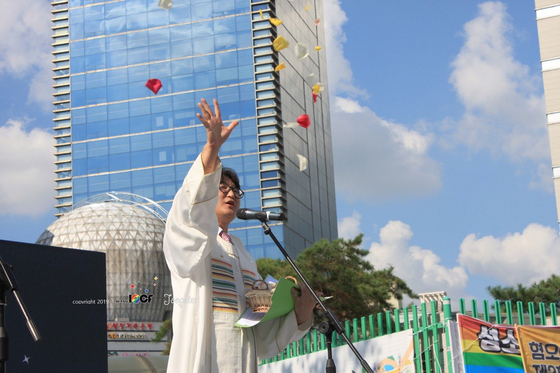 Pastor Lee Dong-hwan throws petals into the air while giving a blessing on Aug. 31, 2019, at the second Incheon Queer Culture Festival. [YONHAP]