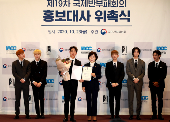 Jeon Hyun-heui, center right, chairperson of the Anti-Corruption and Civil Rights Commission (ACRC), appoints boy band Monsta X as the “publicity ambassadors” of the International Anti-Corruption Conference (IACC) last month at Coex in Gangnam District, southern Seoul. [ACRC]