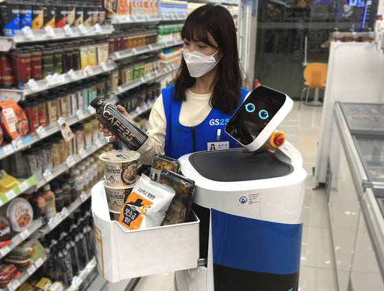 A GS25 employee fills LG Electronics' CLOi robot with items for delivery. [GS25]