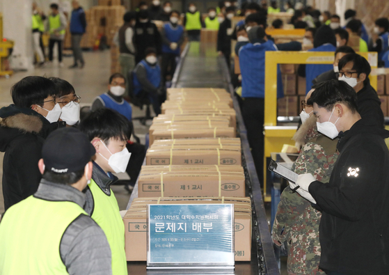 Workers sort boxes of test sheets for this year’s College Scholastic Ability Test (CSAT) at a printing factory in Sejong City Monday, three days ahead of the exam. [YONHAP]
