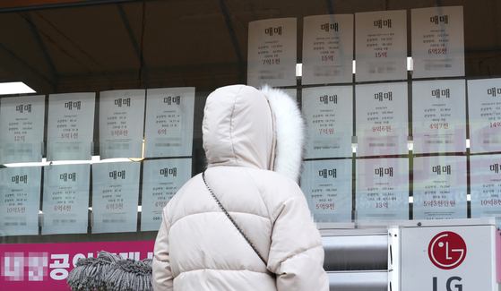 A customer looks at sales postings at a real estate agency in Sejong on Tuesday. According to the Korea Appraisal Board, jeonse long-term rent prices in Sejong rose 4.3 percent last month compared to the previous month. The nationwide jeonse prices jumped the most in seven years. [YONHAP]