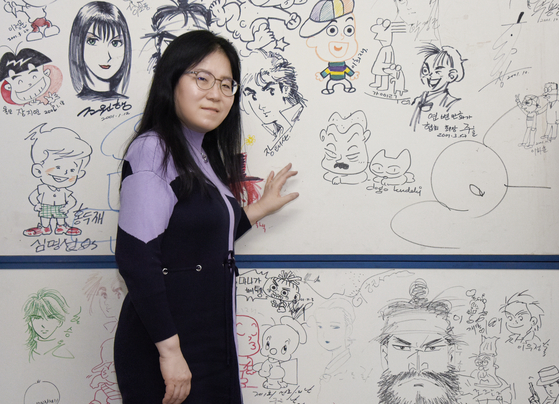 Cartoonist and President of the Korea Cartoonist Association Shin Eel-suk poses in front of a collection of drawings by Korean cartoonists at the association's office located in Seongsu District, eastern Seoul, during an interview with the Korea JoongAng Daily. [JEON TAE-GYU]
