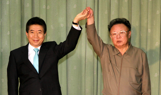 Former South Korean President Roh Moo-hyun, left, holds hands with former North Korean leader Kim Jong-il in 2007 during their summit in Pyongyang. [YONHAP]