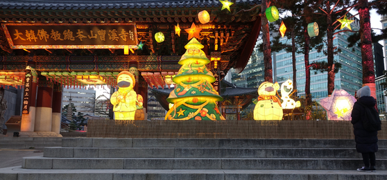 Christmas decorations light the entrance of Jogye Temple in Jongno District, central Seoul, Tuesday. The temple announced it would cancel its annual tree-lighting event with Christian religious leaders this year due to the pandemic. [YONHAP]