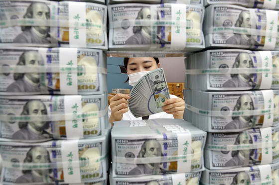 A staffer organizes U.S. dollars at KEB Hana Bank's main branch in Jung District, central Seoul, earlier this month. [YONHAP] 
