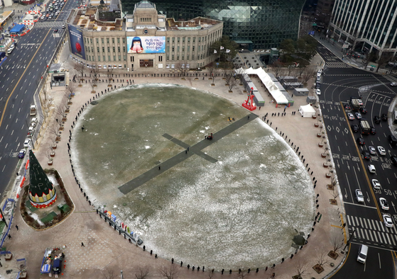 People line up in front of Seoul City Hall on Friday to receive Covid-19 tests at a Jung District makeshift testing center. [YONHAP]