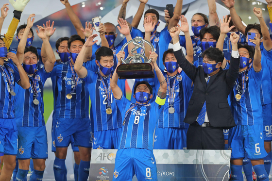 Ulsan Hyundai FC midfielder Sin Jin-Ho lifts the winners' trophy after the Asian Football Confederation Champions League finals match between Iran's Persepolis FC and Korea's Ulsan on Saturday in Qatar. [AFP/YONHAP]