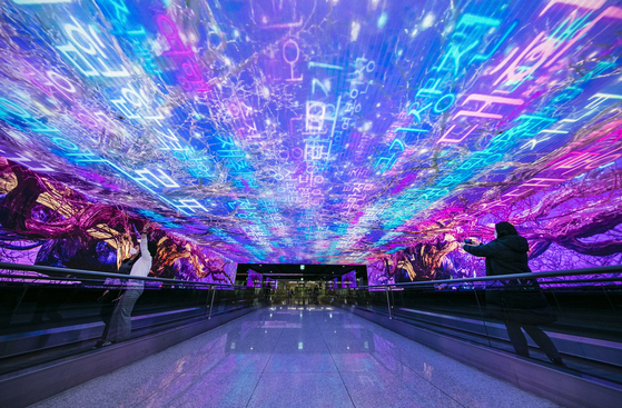 Customers view media art "Pivotal Tree" at Incheon International Airport Terminal 1. The airport said Monday it collaborated with cosmetics giant Amorepacific and the Seoul Foundation for Arts and Culture to open an exhibition of art that reinterprets traditional Korean culture. The works are available from January next year at the airport's Media Wall. [YONHAP]