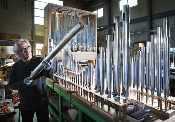 Orgelbaumeister Hong Sung-hoon looks at metal pipes as he works on completing his 20th pipe organ in his studio in Yangpyeong, Gyeonggi. The organ will be placed in the music hall in Jeonju Kijeon College in Jeonju, North Jeolla. [PARK SANG-MOON]