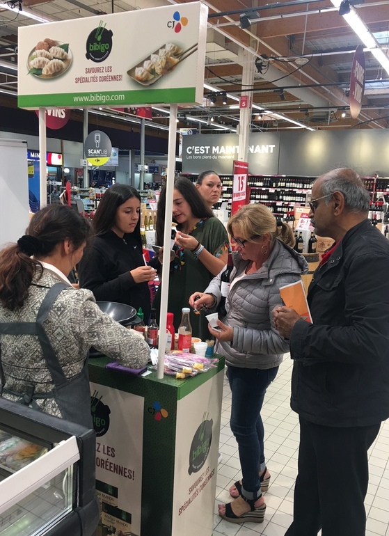 Shoppers trying Bibigo mandu, or dumplings, at a retailer in France. [CJ CHEILJEDANG]