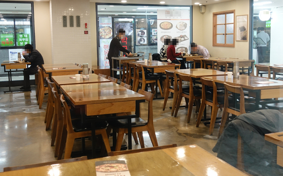 A restaurant in downtown Seoul sits empty Tuesday as soaring coronavirus cases devastate local businesses. [YONHAP]
