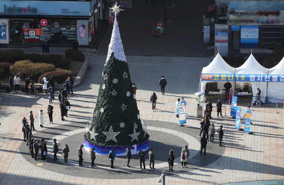 People wait in line outside a Covid-19 testing site in Seongnam, Gyeonggi, Thursday to get tested. [YONHAP] 