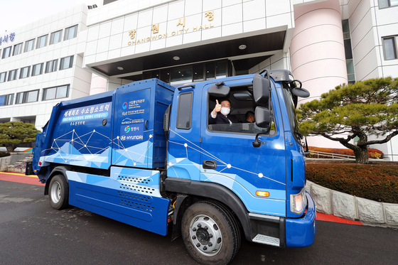 Mayor of Changwon City Huh Sung-moo rides a hydrogen-powered garbage truck in front of Changwon City Hall in Changwon, South Gyeongsang, on Monday. The city is testing the five-ton hydrogen truck developed by the Korea Automotive Technology Institute and Hyundai Motor. [CHANGWON CITY HALL]