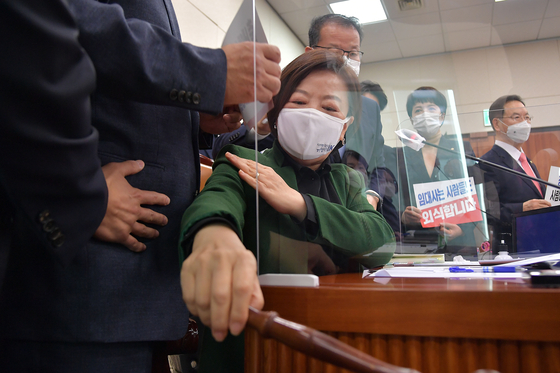 Chairwoman Jin Sun-mee of the Land, Infrastructure and Transport Committee, also a ruling Democratic Party lawmaker, is surrounded by opposition People Power Party lawmakers attempting to block the committee from passing a favorable confirmation hearing report on Land Minister-nominee Byeon Chang-heum on Monday. [YONHAP] 