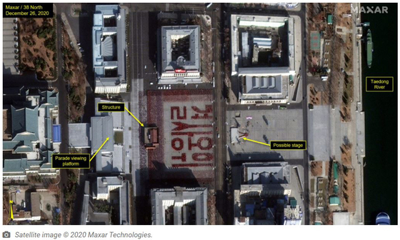 A rehearsal is underway in Pyongyang's Kim Il Sung Square in this satellite photograph, uploaded by monitoring group 38 North. Participants hold up red placards which, in a formation, spell out a phrase that means "defend with one's life." [SCREEN CAPTURE]