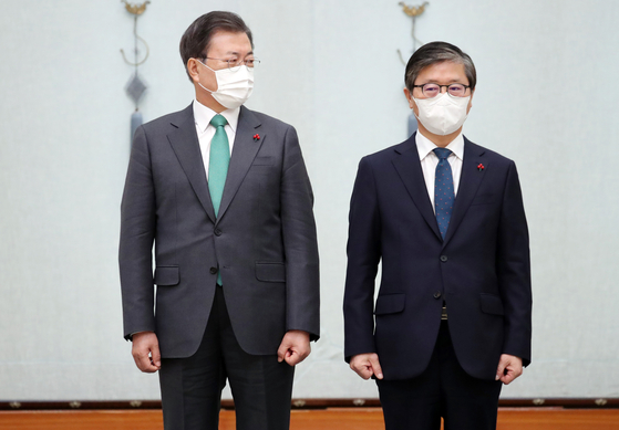 President Moon Jae-in, left, poses with the new Minister of Land, Infrastructure and Transport, Byeon Chang-heum, at the Blue House on Tuesday. Byeon is the 26th cabinet member under President Moon to have been approved without the consent of the opposing party. [YONHAP]