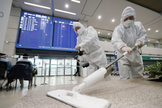 Officials disinfect Incheon International Airport on Monday as health authorities announced Korea’s first detection of a highly transmissible coronavirus variant now sweeping Britain. [NEWS1]